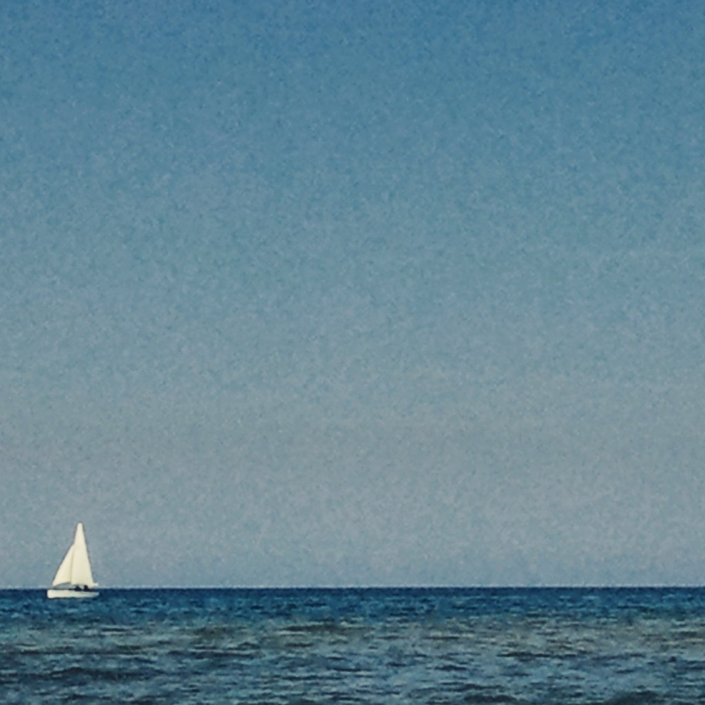 Una barca a vela solca le onde del litorale domitio